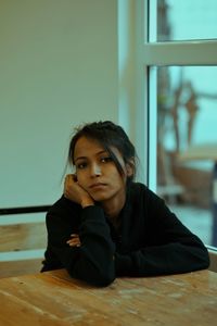 Portrait of young woman sitting at home