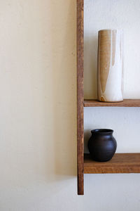 Close-up of bowl on table against wall at home