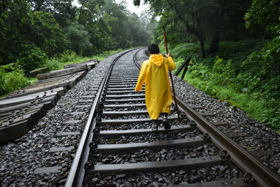 Rear view of boy standing on railroad track - dudhsagar trek