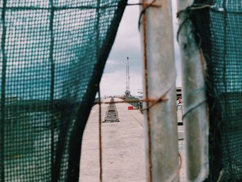 Pier against sky seen through net