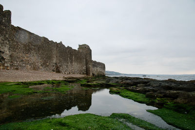 Rock formations by sea against sky