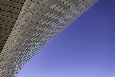 Low angle view of modern building against clear blue sky