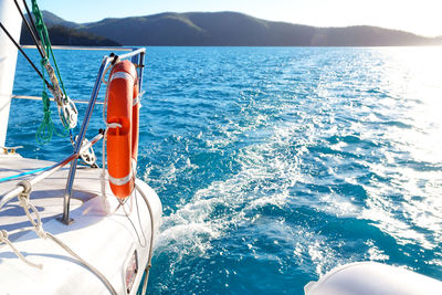 Sailboat sailing in sea against mountains