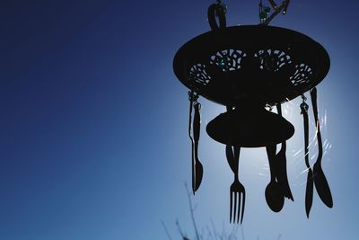 Low angle view of electric lamp against blue sky