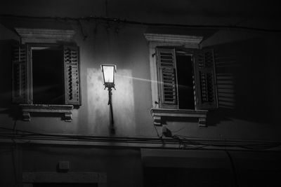 Low angle view of illuminated street light against building