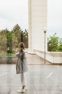 Full length of woman photographing on mobile phone