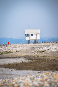 Built structure on beach against clear sky