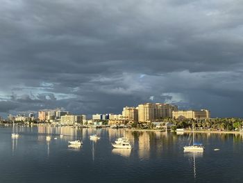 City buildings by sea against sky