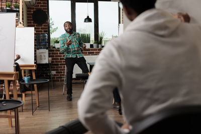 Rear view of man standing in cafe