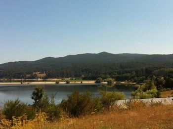 Scenic view of lake and mountains against clear sky