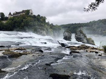 Scenic view of waterfall against sky