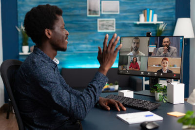 Man using laptop while sitting on table