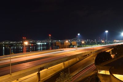 Light trails on elevated road against clear sky at night