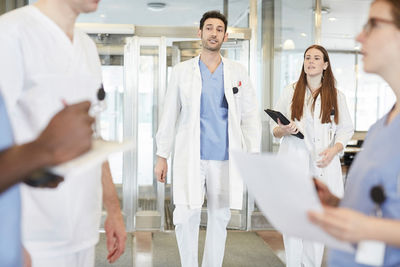 Multi-ethnic healthcare team discussing at lobby in hospital