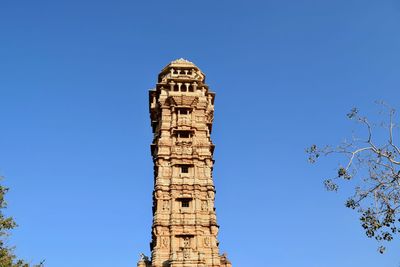 Low angle view of vijaya stambha against clear blue sky