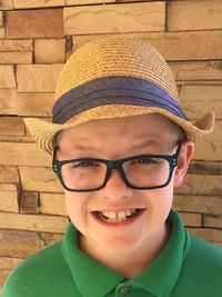 Portrait of smiling boy wearing hat against wall