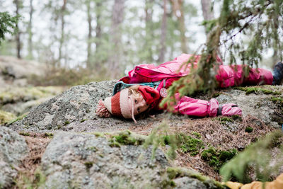 Young girl laying on a rock whilst hiking in a forest in sweden