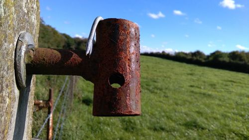 Close-up of rusty metal chain against sky