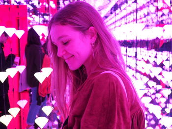 Portrait of smiling young woman with pink petals