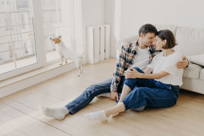 Couple sitting by sofa at home