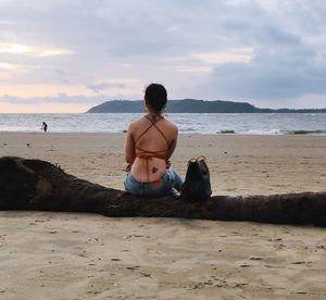 Rear view of man sitting on beach