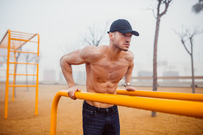 Athletic man doing exercises for triceps in a calisthenics park