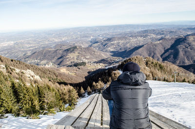 Man looking at mountains against sky