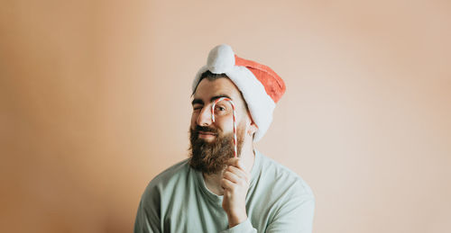 Man with santa hat against wall