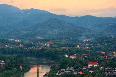 Scenic view of townscape by mountains against sky