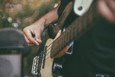 Midsection of man playing guitar