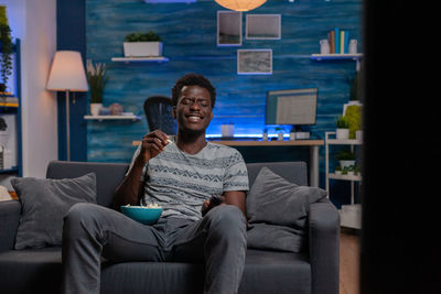 Smiling man eating popcorn while watching movie