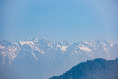 Scenic view of snowcapped mountains against clear blue sky