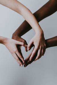 Cropped hands of women against gray background