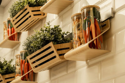 Spices in glass jars on shelf, wooden glass cups on kitchen wooden wall. cookware concept