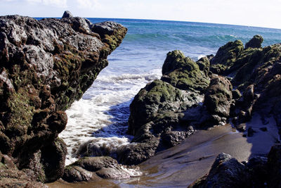 Rocks on beach against clear sky