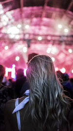 Rear view of woman at illuminated nightclub