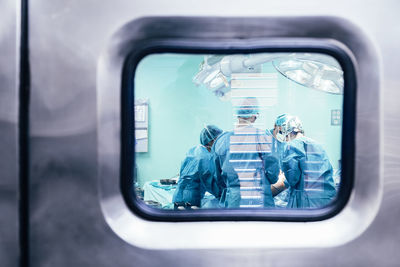 Doctors in operation theater seen through glass