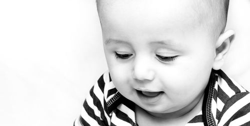 Close-up of cute baby girl against white background