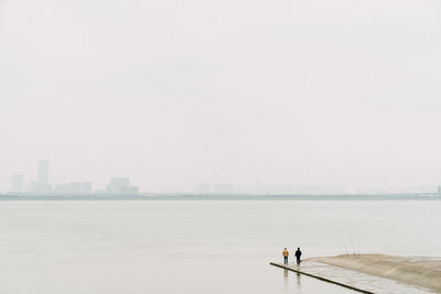 Man standing by sea against clear sky