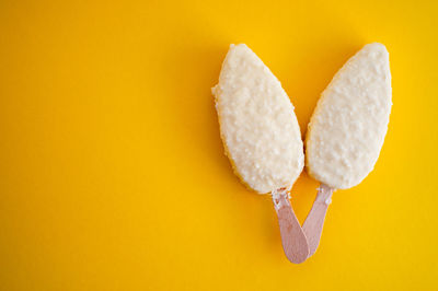 Directly above shot of ice cream popsicles on yellow background