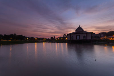 Scenic view of illuminated buildings against sky at sunset