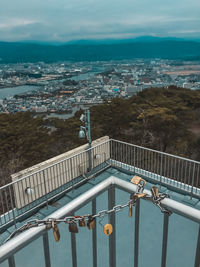 Scenic view of river by cityscape against sky