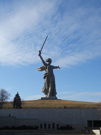 Low angle view of angel statue against cloudy sky