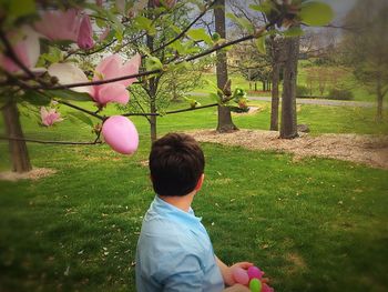 Rear view of man with balloons at park