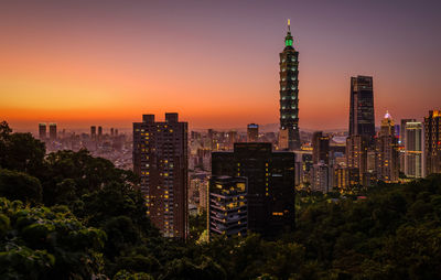 Aerial view of illuminated buildings in city at dusk
