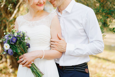 Midsection of couple holding hands