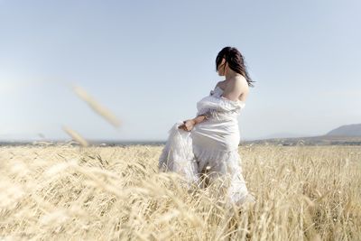 Side view of woman standing on field