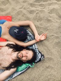 Portrait of young couple lying on beach