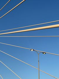 Low angle view of cables against blue sky