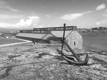 Empty bench at beach against sky